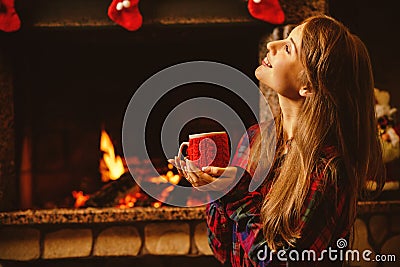 Woman with a mug by the fireplace. Young attractive woman sittin Stock Photo