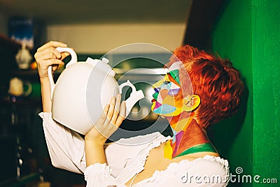 A woman with multi-colored make-up and orange hair Stock Photo