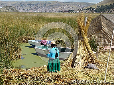 Woman near her family boats at one of the Uros' islands - Lake Titicaca Editorial Stock Photo