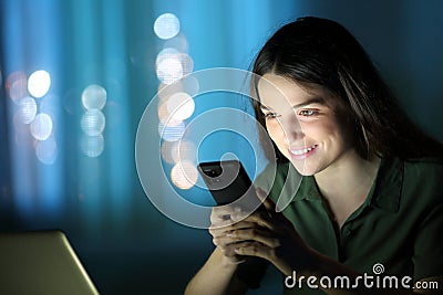 Woman in the night checking cell phone Stock Photo