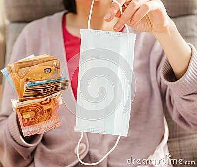 Woman offering for stack of money banknotes surgical procedure medical face mask Stock Photo