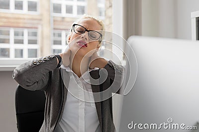 Woman at the office having neck pain Stock Photo