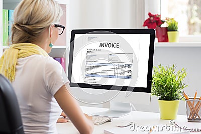 Woman in office with sample invoice document on computer Stock Photo