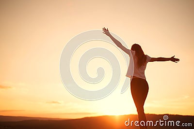 Woman open arms under the sunset. Concept of healthy life. Stock Photo