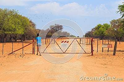 Woman open the gate on gravel road to Waterberg Plateau National Park, Namibia Editorial Stock Photo