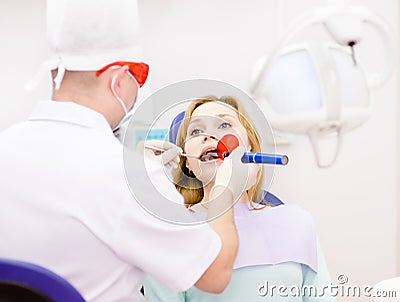 woman with open mouth receiving dental filling dry Stock Photo