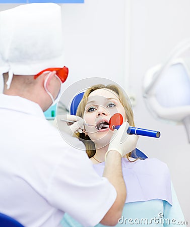 Woman with open mouth receiving dental filling dry Stock Photo