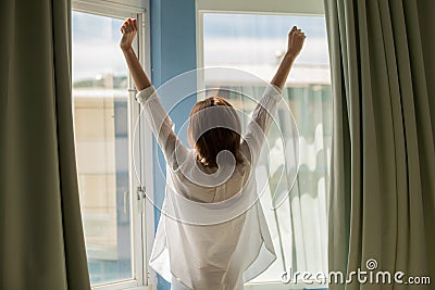 Woman opening curtains Stock Photo