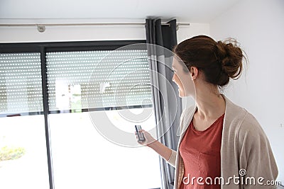 Woman opening electric shutters Stock Photo