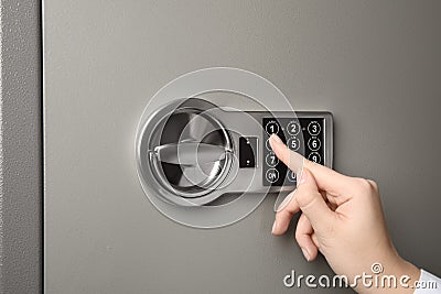 Woman opening steel safe with electronic lock Stock Photo