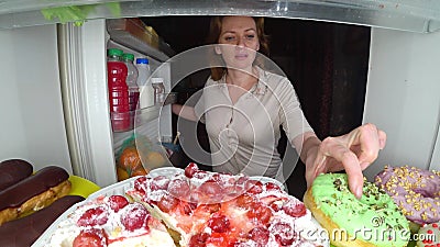Woman opens the refrigerator at night. night hunger. diet gluttony Stock Photo