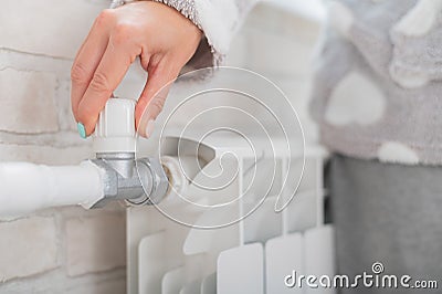 The woman opens the valve of the radiator heating. Stock Photo