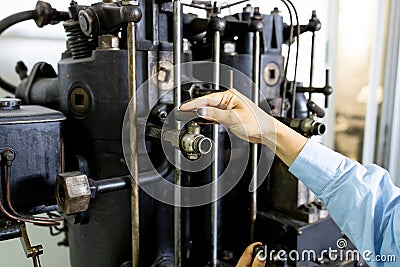 A woman operates a complex mechanism. A girl working in a factory. Stock Photo