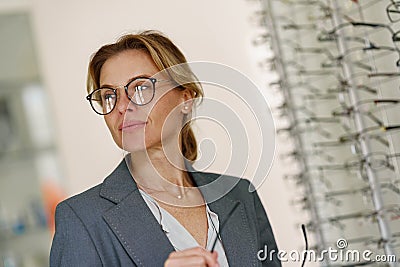 Woman in optic store choosing a new eyeglasses frame. Medical, health care concept Stock Photo