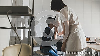 Woman optometrist examining pre adolescent boy`s eyes in ophthalmology clinic Stock Photo