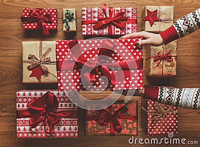 Woman organising beautifully wrapped vintage christmas presents on wooden background, image with haze Stock Photo