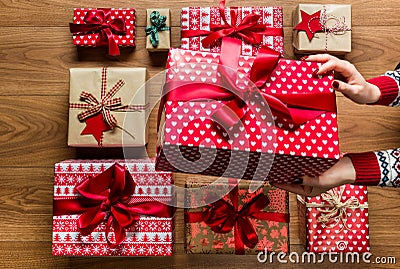 Woman organising beautifuly wrapped vintage christmas presents on wooden background Stock Photo