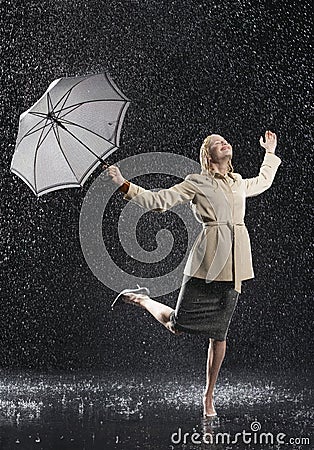 Woman In Overcoat With Umbrella Enjoying The Rain Stock Photo