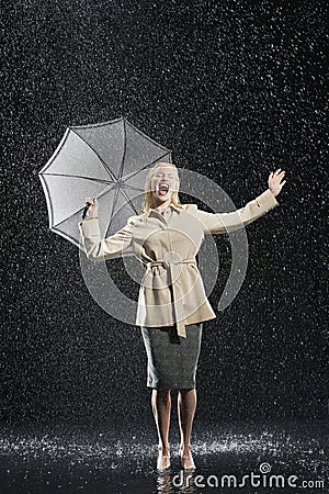 Woman In Overcoat With Umbrella Enjoying The Rain Stock Photo