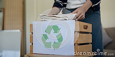 Woman pack box with used clothes for reuse. Reusing, recycling material and reducing waste in fashion, second hand Stock Photo