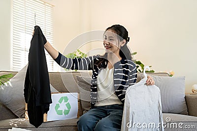 Woman pack box with used clothes for reuse. Reusing, recycling material and reducing waste in fashion, second hand Stock Photo