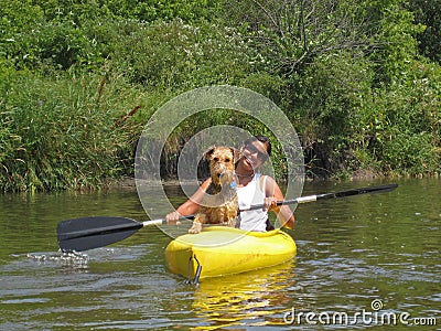 Woman paddler with dog in yellow kayak Stock Photo