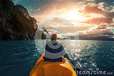 Woman paddles kayak Stock Photo