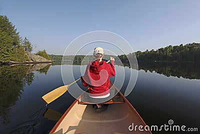 Woman Paddling a Canoe on a Northern Ontario Lake Stock Photo