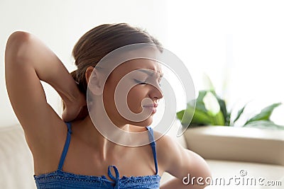 Woman suffering because of strong upper back pain Stock Photo