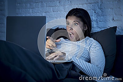 Woman in pajamas on bed at home bedroom working concentrated with laptop computer late at night Stock Photo