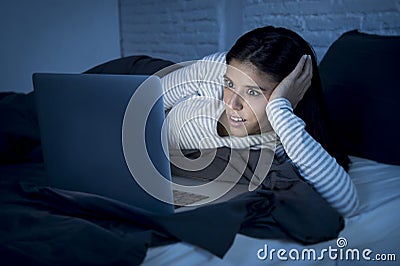 Woman in pajamas on bed at home bedroom working concentrated with laptop computer late at night Stock Photo
