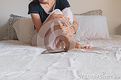 Woman in pajamas reading in bed. Stock Photo