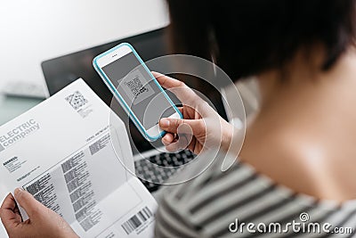 Woman paying bills with her smartphone Stock Photo