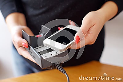Woman paying with NFC technology on mobile phone Stock Photo