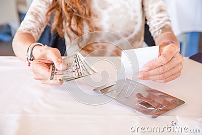Woman paying restaurant bill with dollar banknotes Stock Photo
