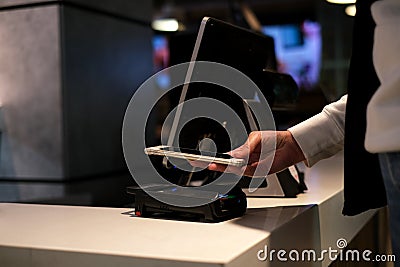 Woman pays contactless via Paypass in store by phone Stock Photo