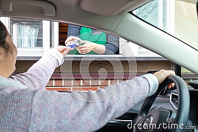 Woman pays for service through Drive thru Stock Photo