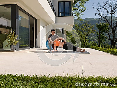 Woman with personal trainer doing morning yoga exercises Stock Photo
