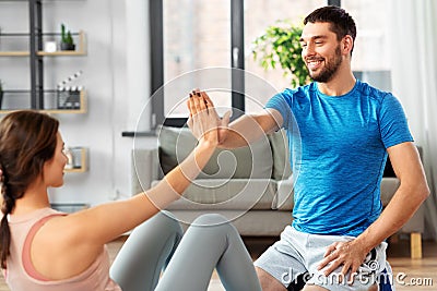 Woman with personal trainer doing sit ups at home Stock Photo