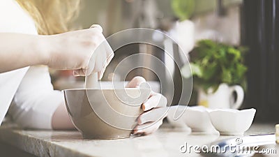 A woman pestling ingredients in a bowl Stock Photo