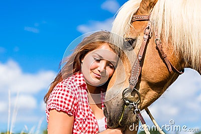 Woman petting horse on pony farm Stock Photo