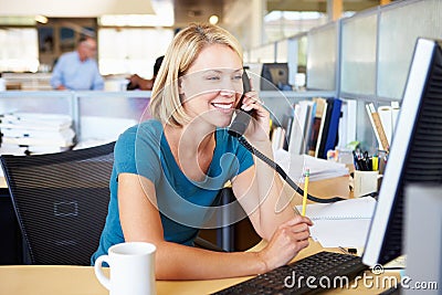 Woman On Phone In Busy Modern Office Stock Photo