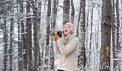 Woman photographer with professional camera. Winter hobby. Enjoy enchanting paleness and freezing atmosphere of winter Stock Photo