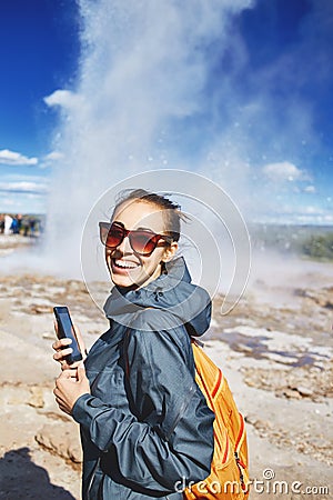 Woman photographing eruption of Strokkur Geyser in Iceland Stock Photo