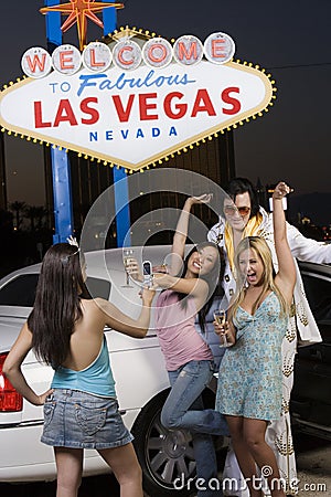Woman Photographing Friends And Elvis Presley Impersonator Stock Photo