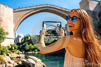 Woman photographing old bridge in Mostar city Stock Photo