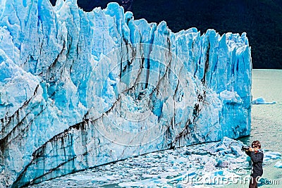 Woman photographs the blue ice wall Stock Photo