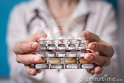 Woman physician holds out the stack of tablets in front of him. the concept of paid medicine Stock Photo