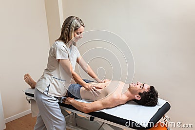 Woman physiotherapist does session to man. visceral ostropathy Stock Photo
