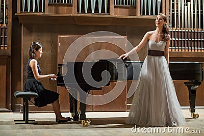 Woman pianist plays the piano and beautiful singer Stock Photo